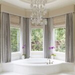 A large bathroom with a tub and chandelier